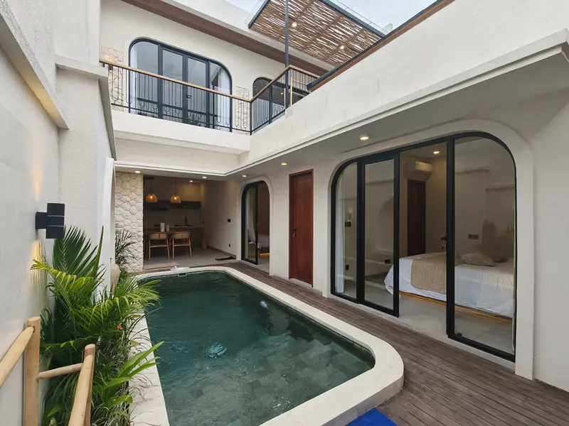Private pool in the villa courtyard, with arched glass doors to the bedroom