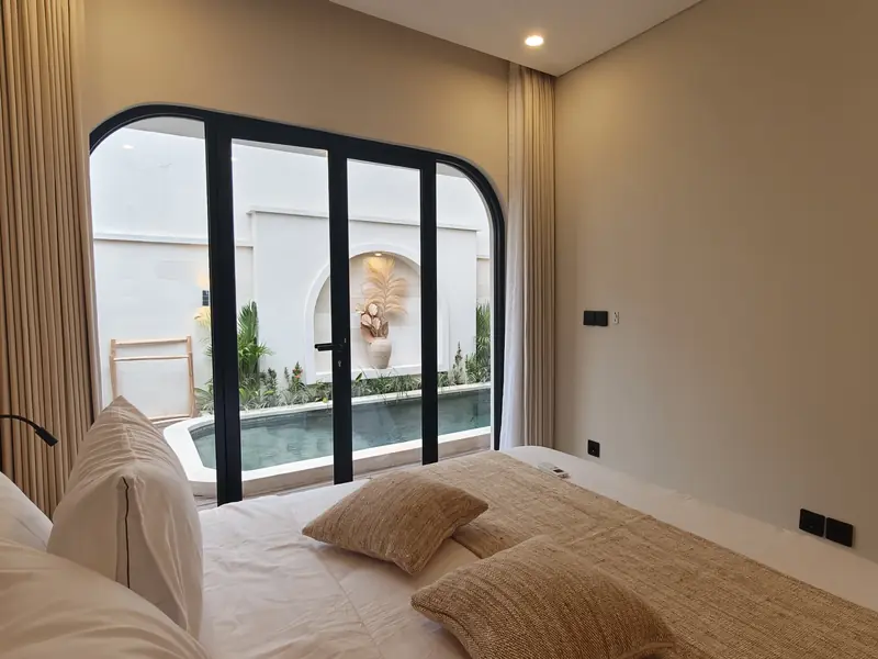 Bedroom with arched doors facing the pool